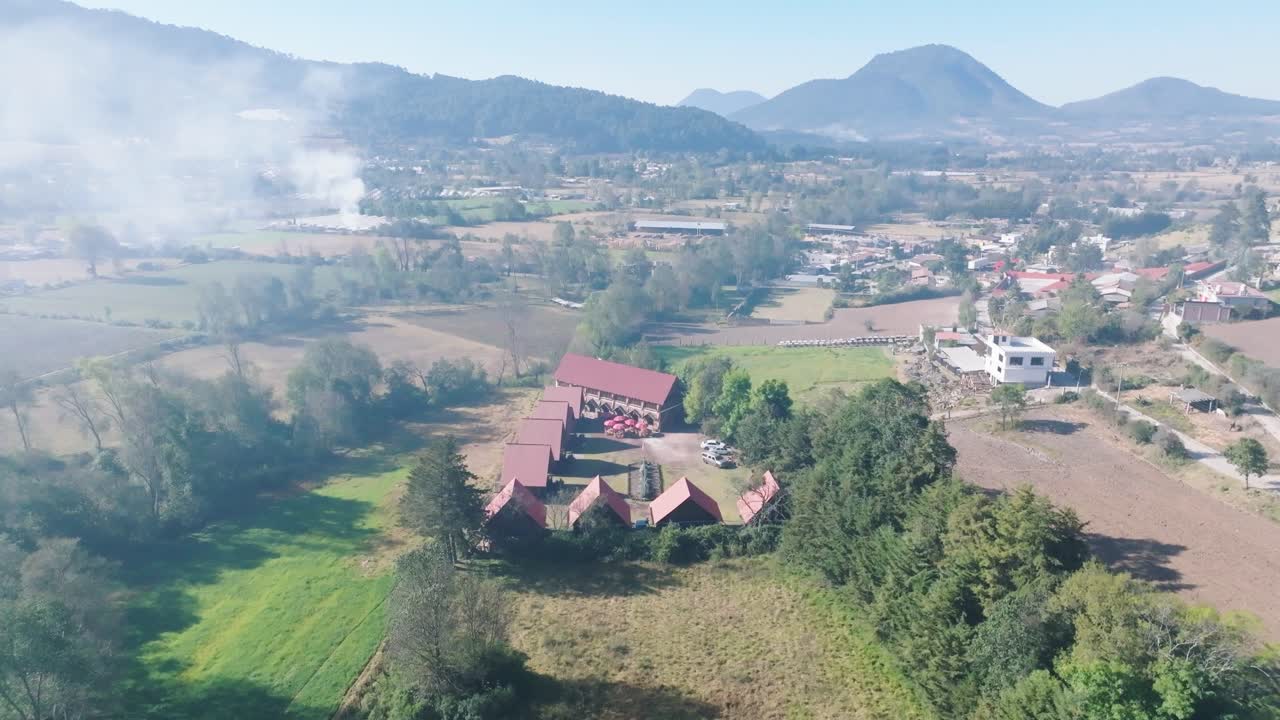 Flyvende over træhytter i et roligt, smukt landskab, Mexico