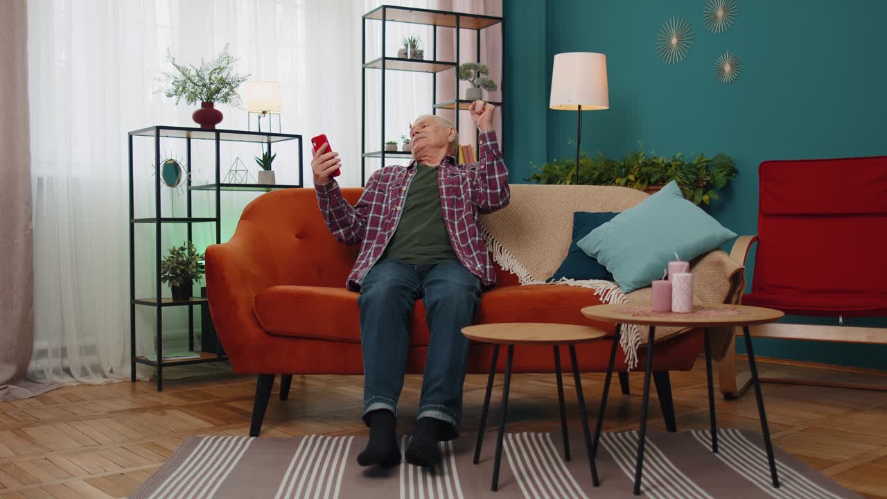 abuelo mayor feliz sosteniendo teléfono inteligente viendo video móvil llamando en línea haciendo selfie en casa