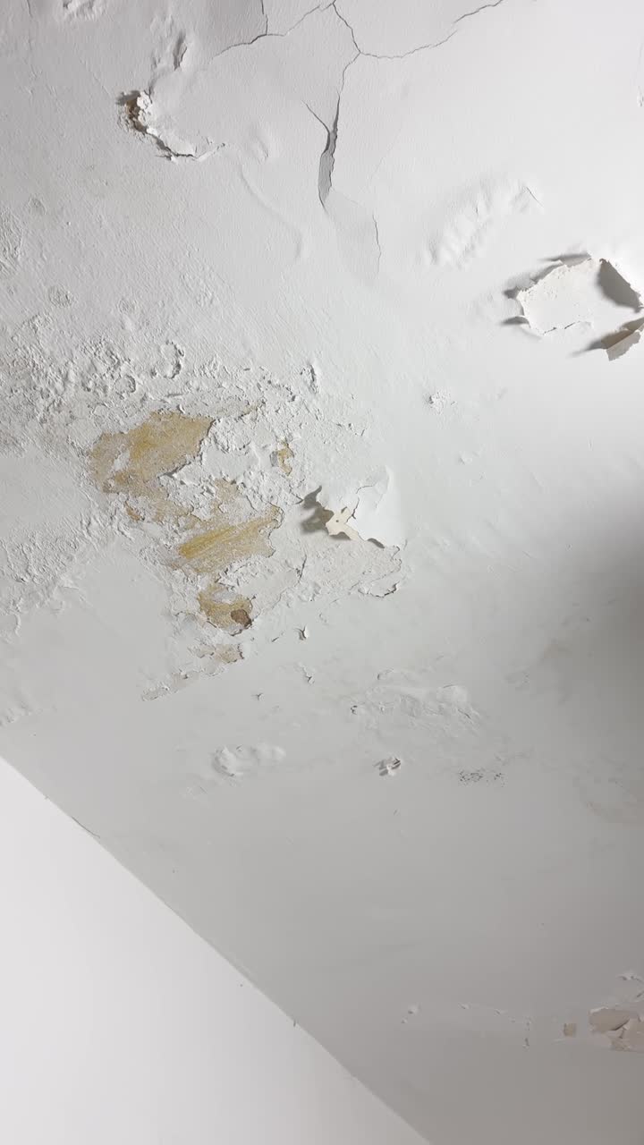 Cracked and peeling wall or ceiling due to moisture or wet pipe or leakage in bathroom house. Old roof needing repair and reconstruction renovation and imporvement. Neglected humidity problem drywall