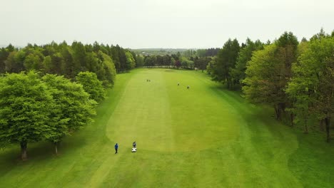 aerial flyover shot of golf fairway on parkland golf course in scotland