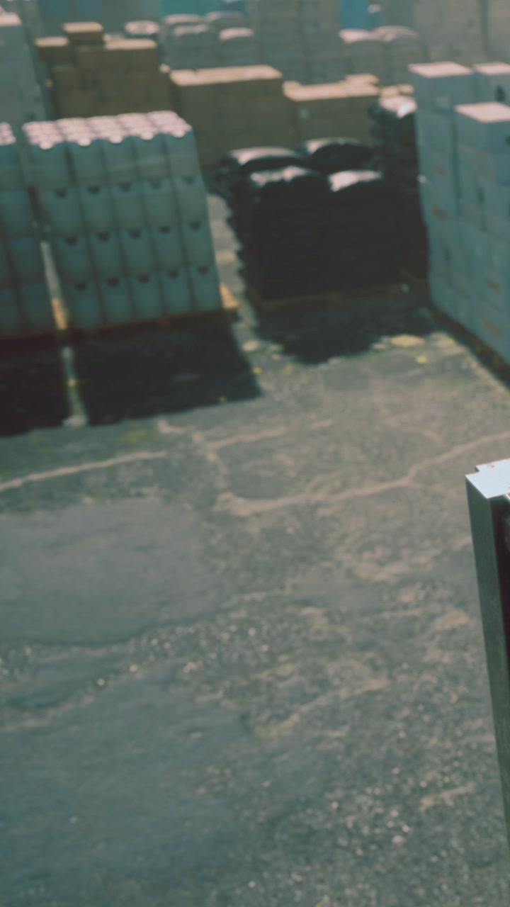 Cargo handling at a loading dock in bright daylight near storage containers