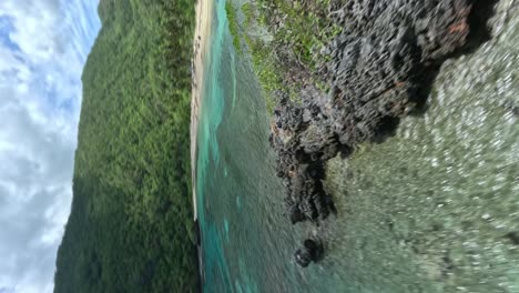 video vertical, hermoso fpv vuelo de carreras sobre el agua turquesa del océano caribeño