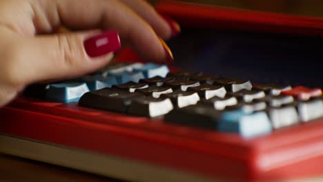 woman using a vintage red calculator
