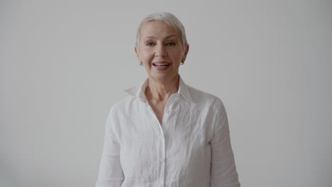 Beautiful-Happy-Senior-Woman-Clapping-Hands-And-Cheering-While-Looking-At-Camera-On-White-Background