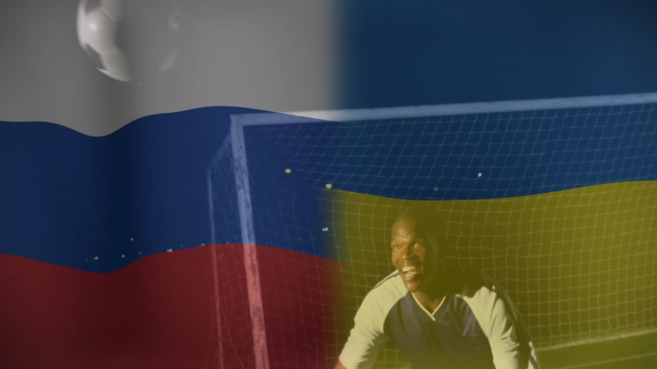 Soccer player leaning by goal net at night, showcasing technology with animated flag stripes