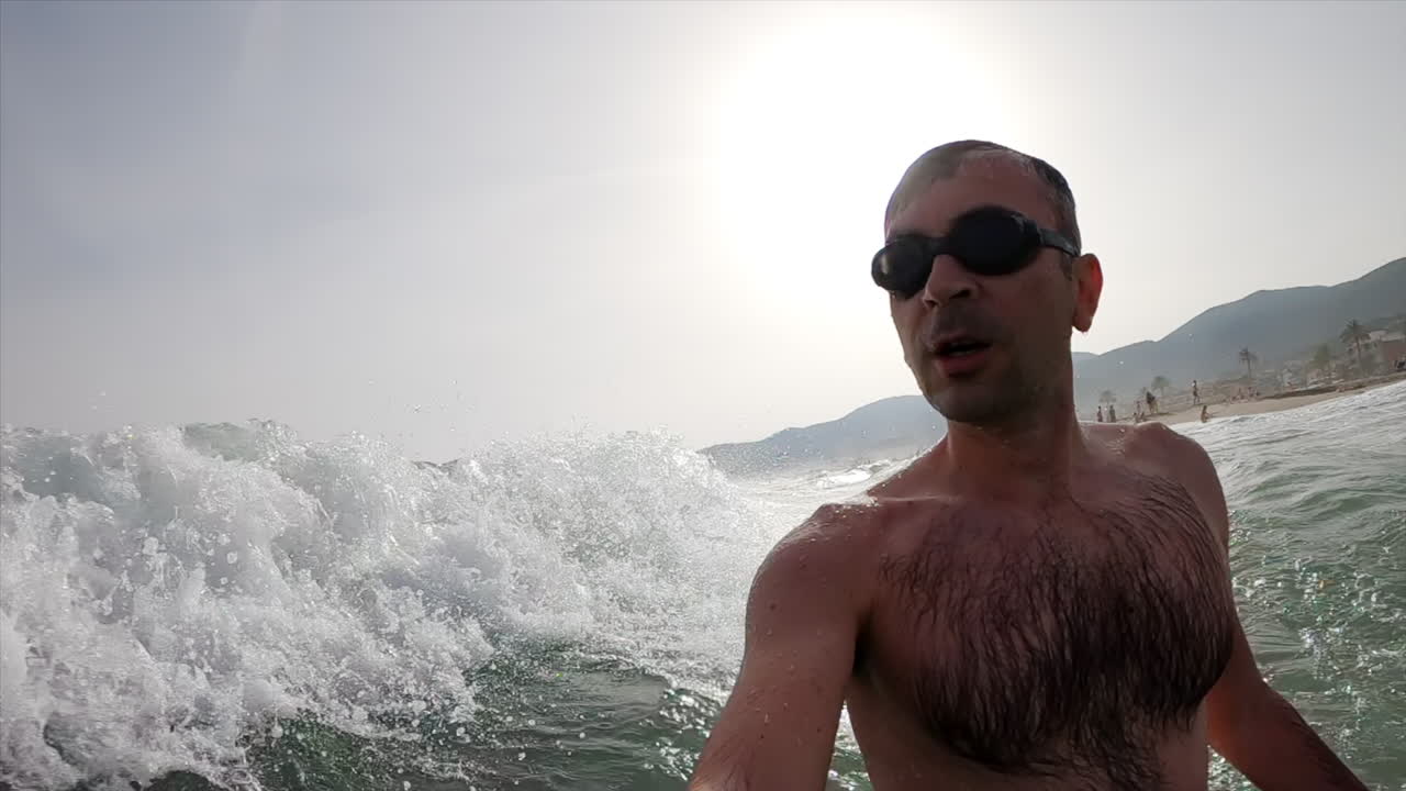 Man wearing swimming googles swimming in the sea