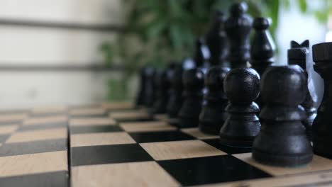 Playing-chess-with-black-pieces,-woman-hand,-close-up