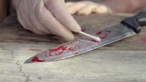 forensic scientist gathers blood sample evidence at crime scene wide shot