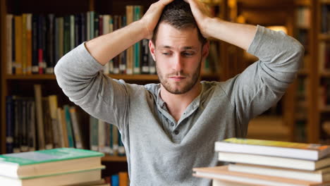 animación de un estudiante masculino maduro estresado con pilas de libros de estudio, sosteniendo la cabeza en la biblioteca