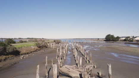 Beautiful-4k-rising-aerial-shot-of-decrepit-Bandon,-Oregon-wooden-pier-supports