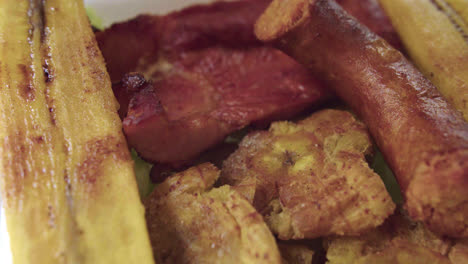 plano detalle de comida de la selva peruana con cecina, patacones, plátano frito y chorizo ahumado