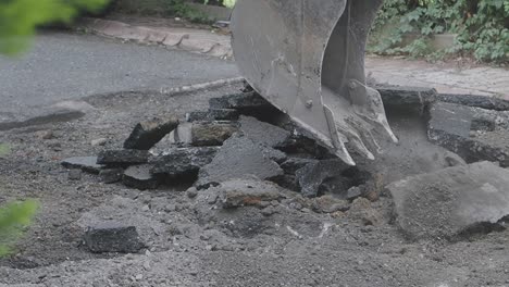 excavator removing asphalt