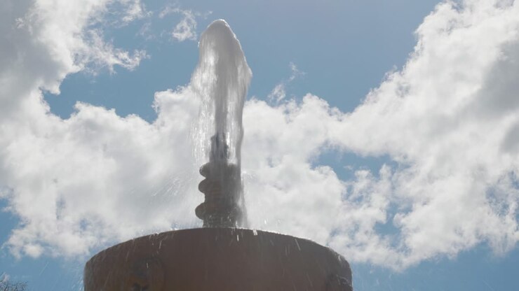 FONTANA IN PIETRA CON UN GETTO D'ACQUA IN UNA GIORNATA NUVOLOSA