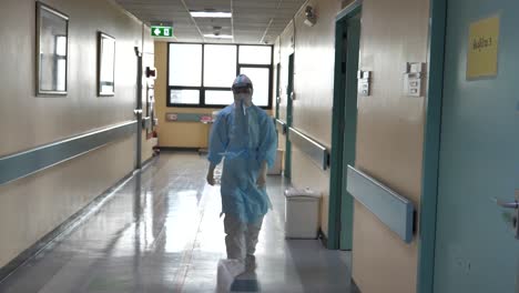 medic wearing full ppe walking in covid-19 hospital hallway
