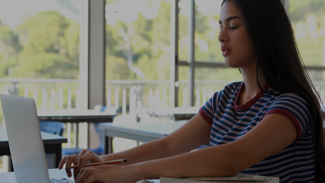 Teen student typing at desk starting HUD growing over laptop studying opening notes then resting