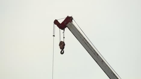 a close up shot of the lifting hook of a tall heavy duty mobile crane on a construction site