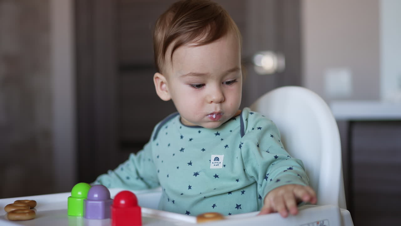 Baby playing with blocks in high chair