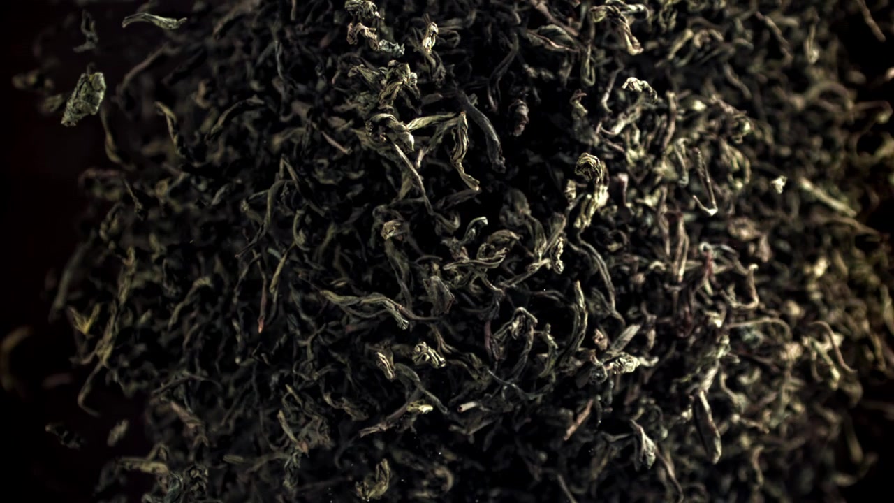 Close-up of Dried Green Tea Leaves Falling in Slow Motion