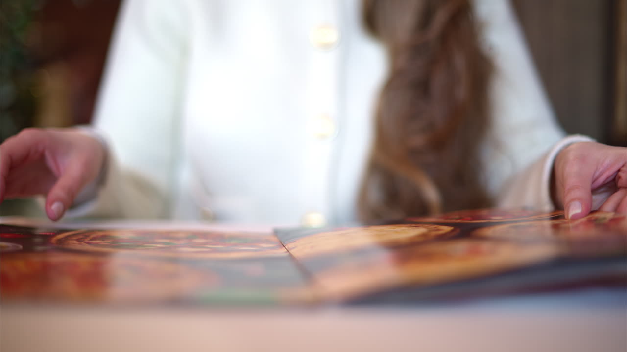 Woman hands in restaurant choosing food in menu
