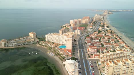 Stunning-aerial-views-of-La-Manga-del-Mar-Menor-beach-in-Murcia-Spain-Mediterranean-Sea-mountains-and-lagoon-in-the-background