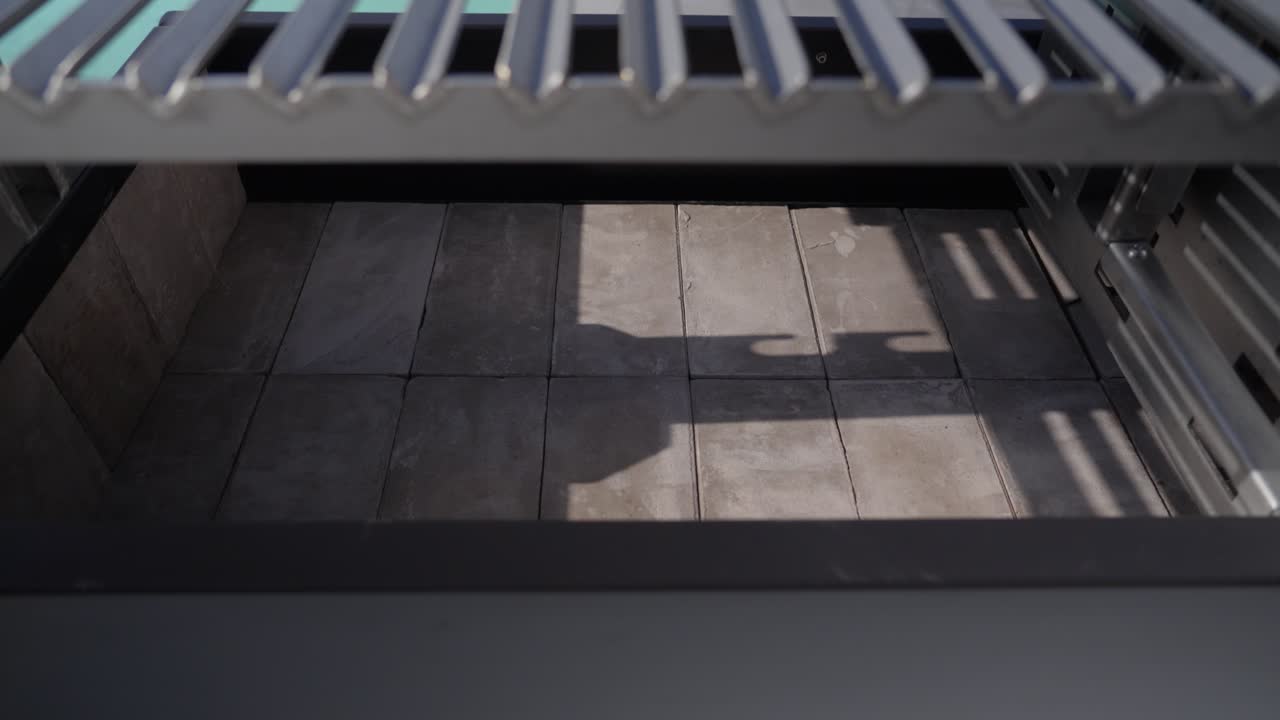 Close up of an empty metal brasero barbecue grill interior with tiled base and steel grate above
