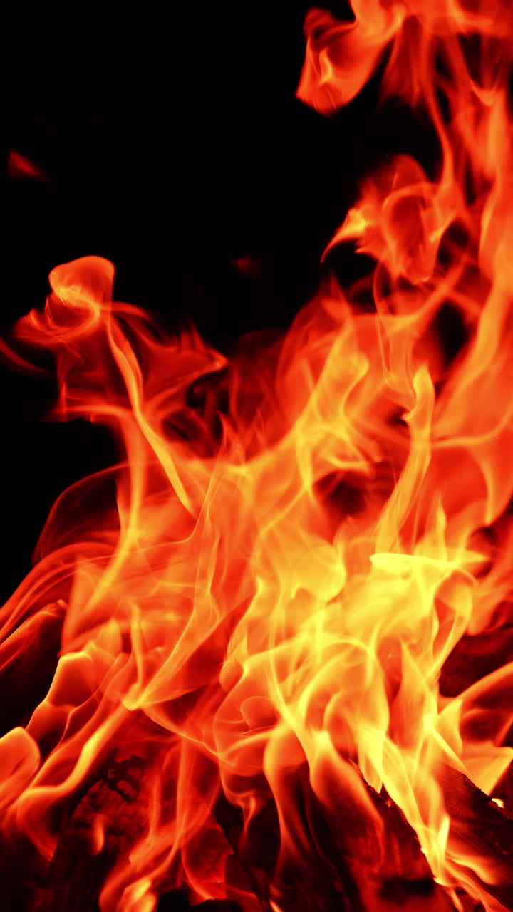 Fiammata con fiamma rossa. Camino caldo che arde con un bagliore arancione. Video verticale