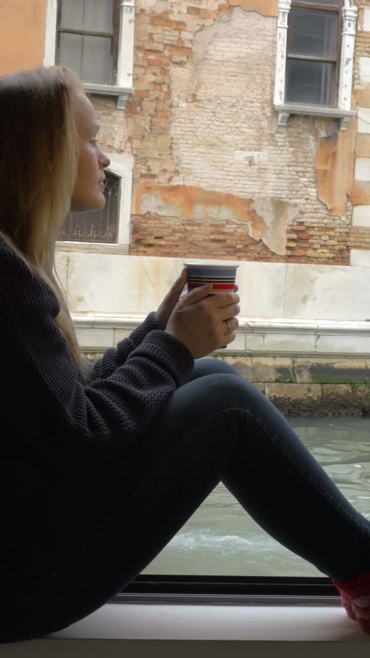Woman sitting by window with cup