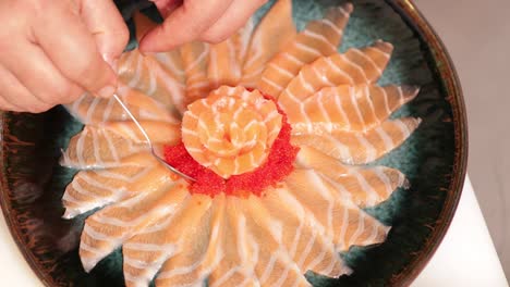 garnishing delicious red caviar on fresh tuna slices