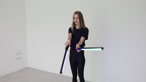 young woman posing with led light tubes in a studio
