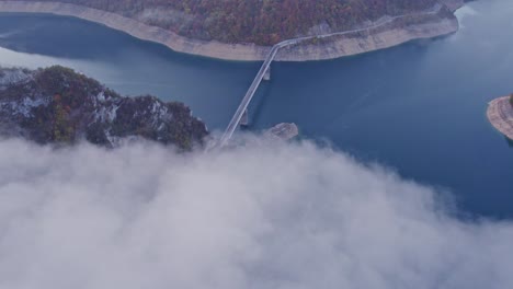 Low-clouds-above-Piva-lake-canyon-at-Montenegro-during-sunrise,-aerial