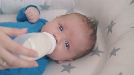 Un-Niño-Pequeño-Come-Una-Mezcla-De-Leche-Con-La-Ayuda-De-Su-Madre-En-Un-Capullo