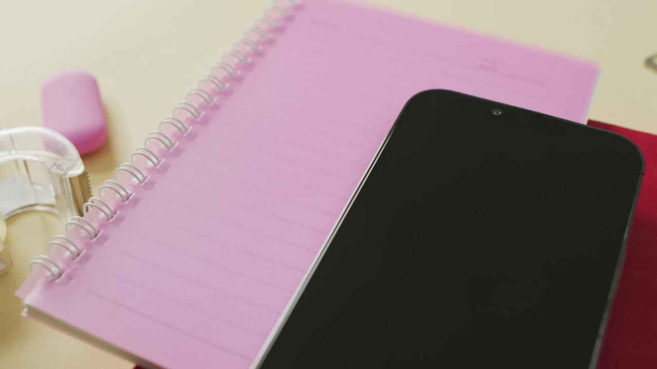 vídeo de un teléfono inteligente con espacio para copiar, cuadernos y equipos escolares sobre fondo amarillo