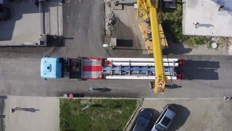 truck with building material and mobile crane arm at construction site