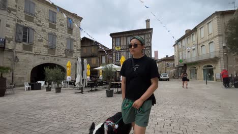 asian woman and a dog sightseeing in a small town in southern france