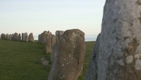 Pasar-A-Pie-De-Vaca-Negra-Ales-Stenar-Con-El-Mar-Báltico-De-Fondo,-En-El-Sur-De-Suecia-Kåseberga,-Österlen,-Portátil