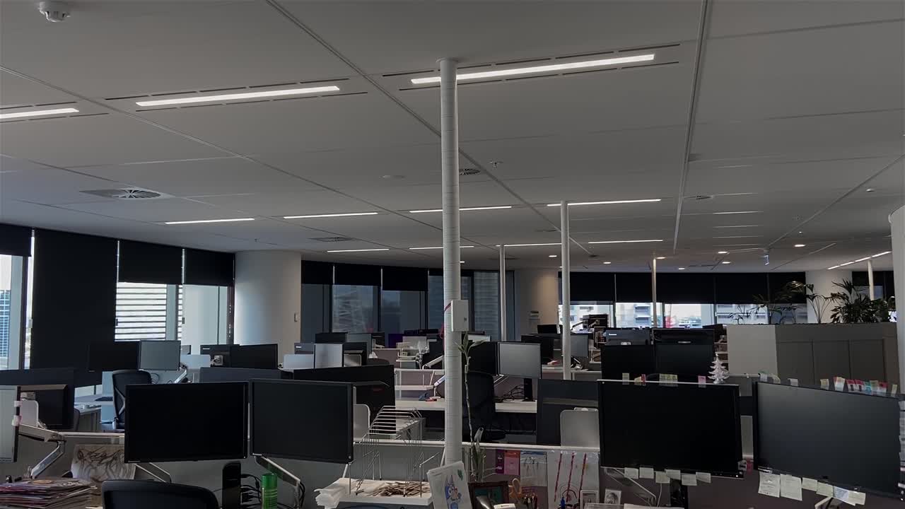 dolly de alta calidad disparó sobre escritorios vacíos en un edificio de oficinas grande y desierto con estaciones de trabajo desatendidas, durante el cierre pandémico del covid-19, con todos los empleados trabajando desde casa