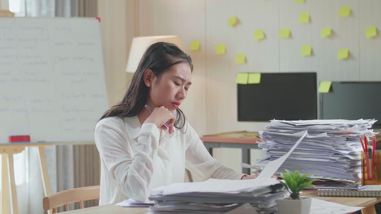 사무실 에서 문서 를 처리 하는 아시아인 여자