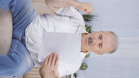 Vertical-video-of-The-old-man-who-rejoices-in-good-content-paperwork.