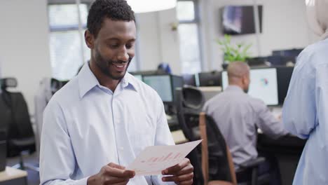 Portrait-of-happy-african-american-businessman-working-with-colleagues-in-office,-slow-motion