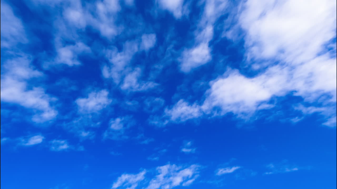 Azure sky with floating white light clouds. Low angle view on the beautiful summer sky. Timelapse.