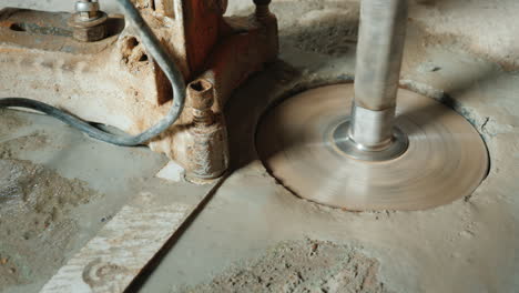 the builder drills holes in the concrete curtain for laying ventilation pipes and plumbing