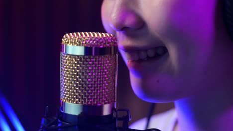 woman singing into microphone in a recording studio