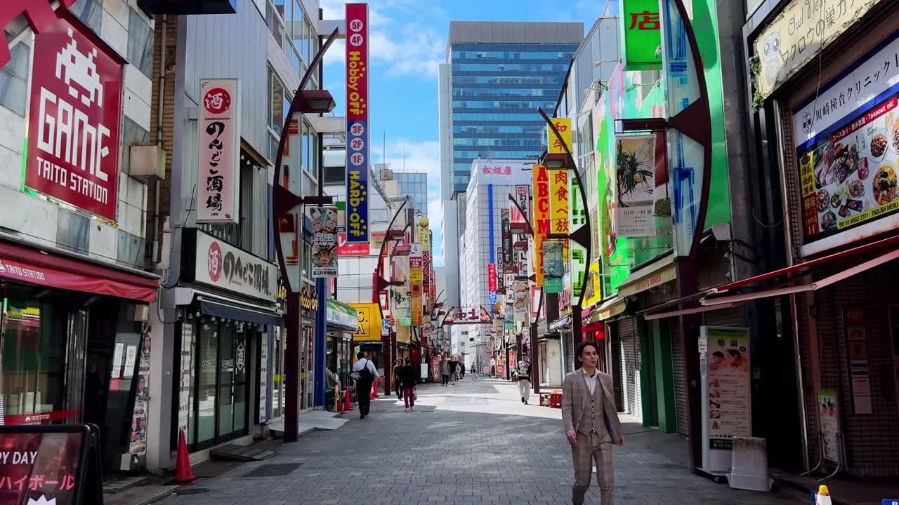 Busy street in Tokyo with colorful signs, tall buildings, and pedestrians walking during daytime