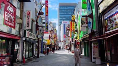 busy street in tokyo with colorful signs, tall buildings, and pedestrians walking during daytime