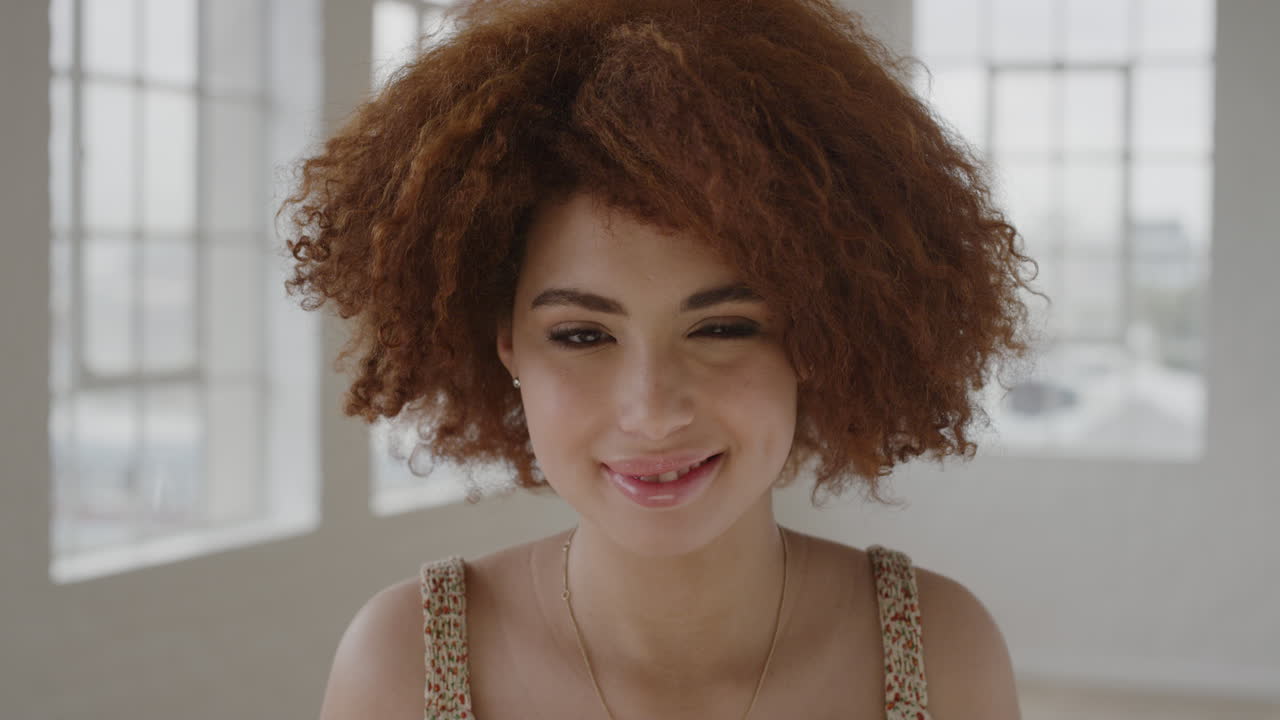 retrato de una joven hermosa sonriente segura de sí misma mirando a la cámara estilo de cabello afro funky estudiante independiente