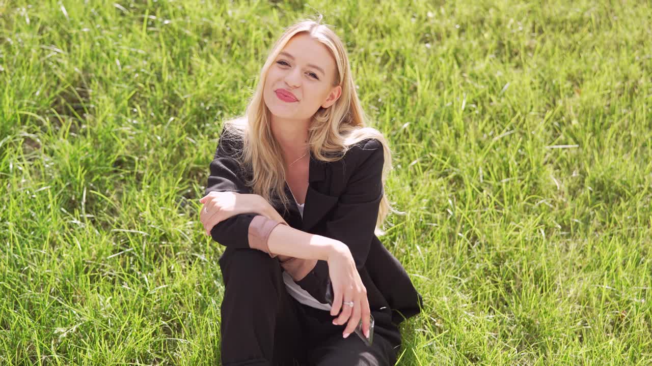 잔디 에 앉아 있는 사업복 을 입은 여자