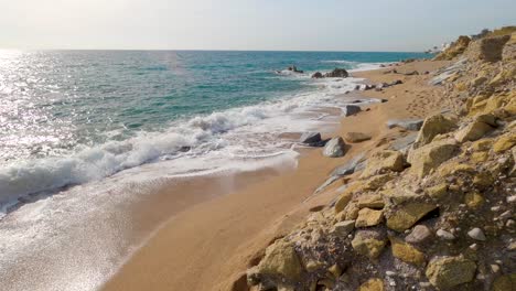 beautiful mediterranean sand beach ,maresme barcelona, san pol de mar, with rocks and calm sea and turquoise , costa brava