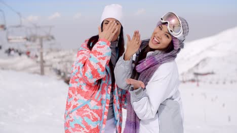 two happy playful young ladies at a ski resort