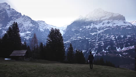 caucasian getting to see the sunrise in front of huge mountains, switzerland alps