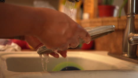 manos vistas lavando platos, ollas y sartenes bajo el agua corriente - cámara lenta